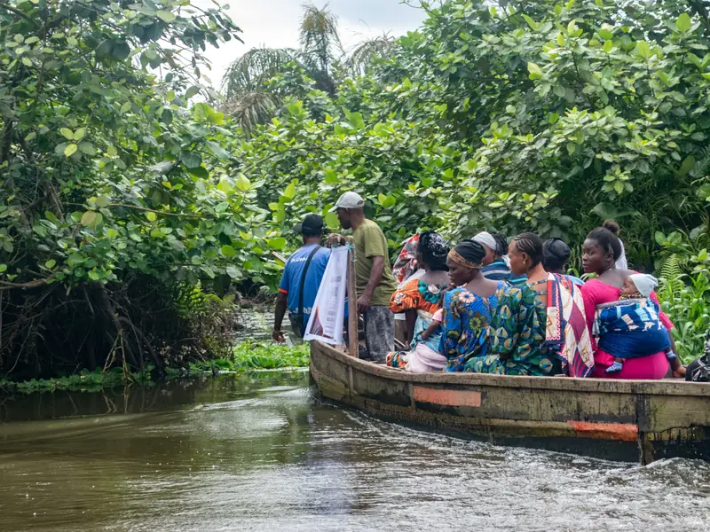 A boat carrying women and volunteers along the waterway.