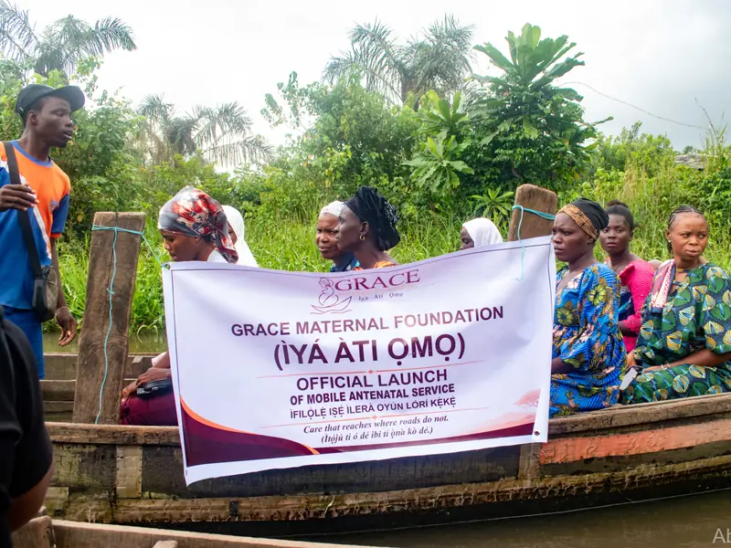 The launch banner held up in the boat, with women seated behind it.