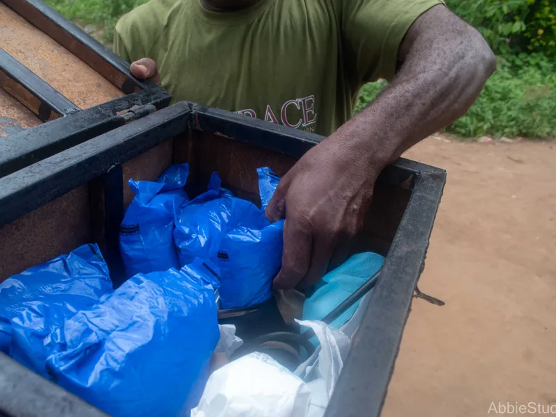 A hand lifting a blue pack from a box of packs.
