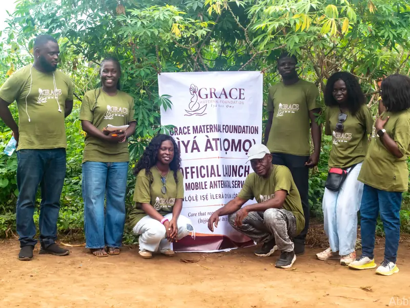 Seven volunteers in Foundation T-shirts standing and crouching with the launch banner.